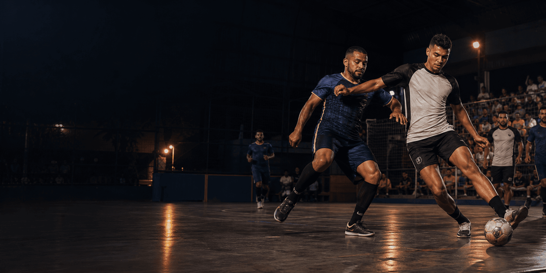 Dois jogadores disputam a bola em uma quadra de futsal durante campeonato